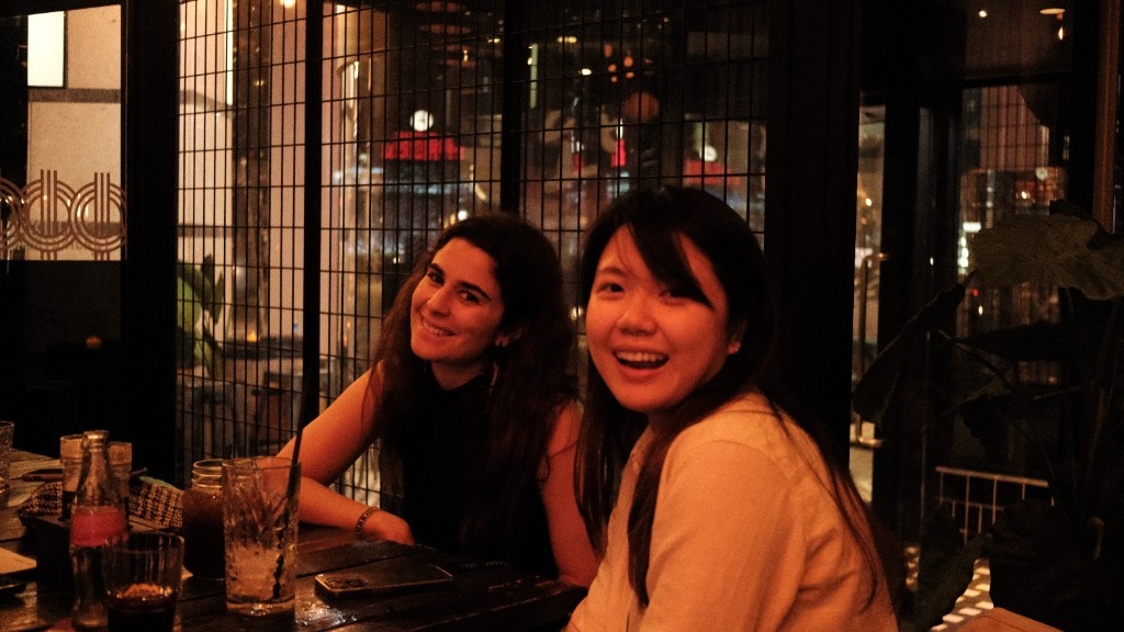 Two women smiling at a table on a night out