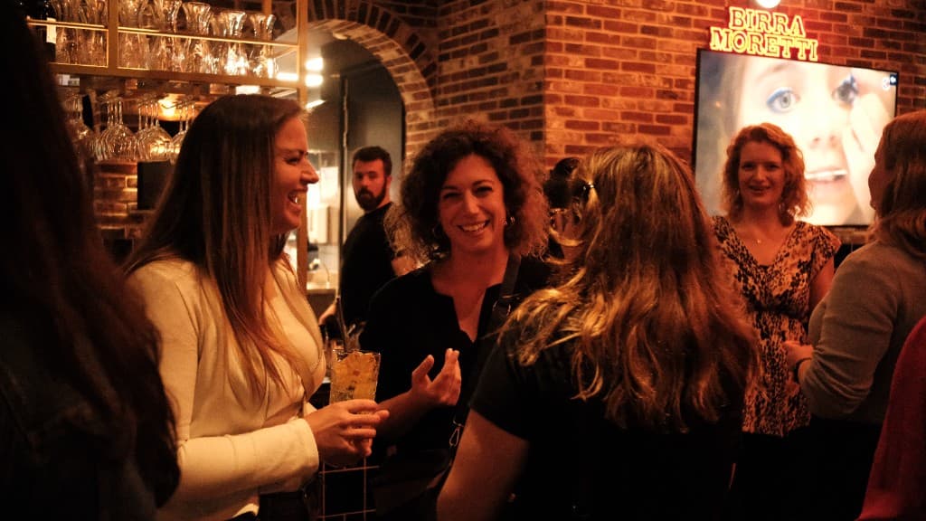 Vrouwen lachen samen aan de bar