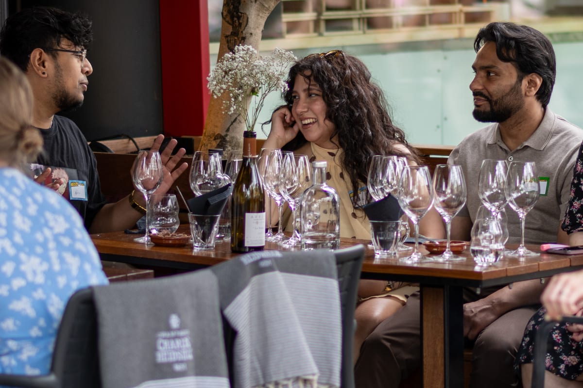Conversation and laughter at a table with wine glasses